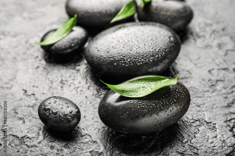 Spa stones and bamboo leaves on dark background