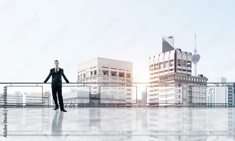 Sunrise above skyscrapers and businessman facing new day