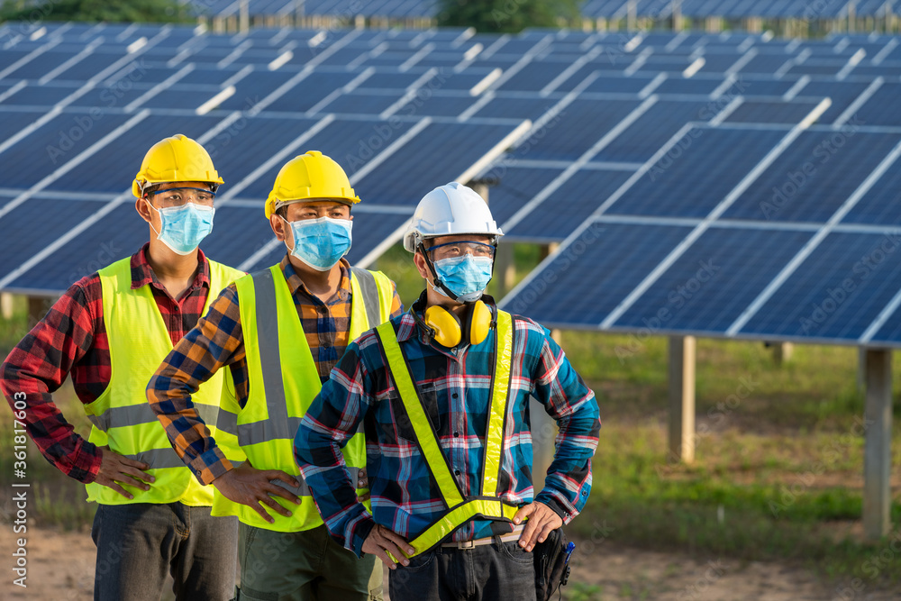 太阳能发电厂，一名电工戴着医用医疗口罩在太阳能发电厂工作和检查