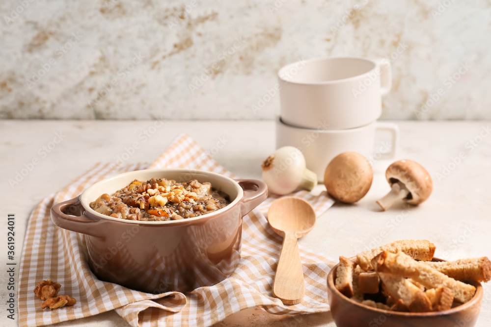 Pot of tasty lentils soup on table