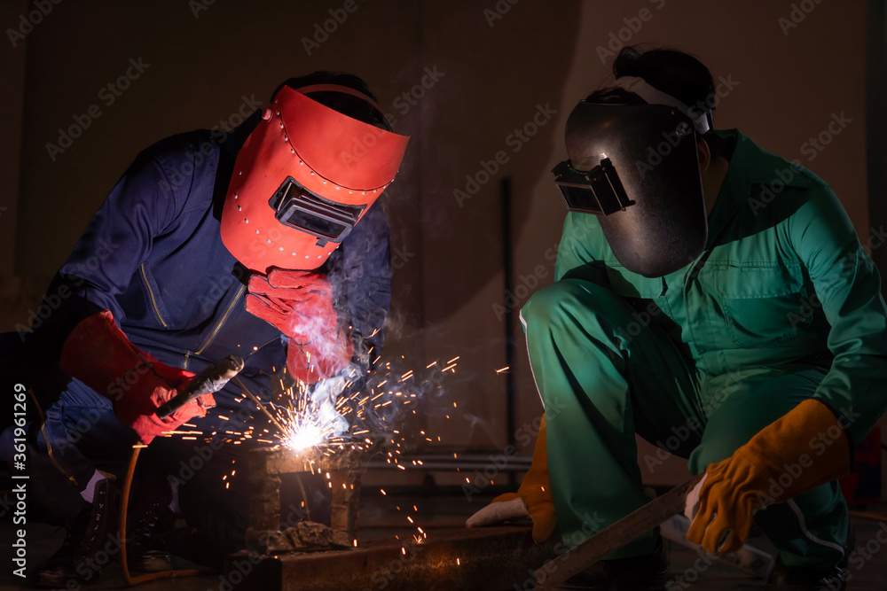 Metal welding steel works using electric arc welding machine to weld steel at factory. Metalwork man