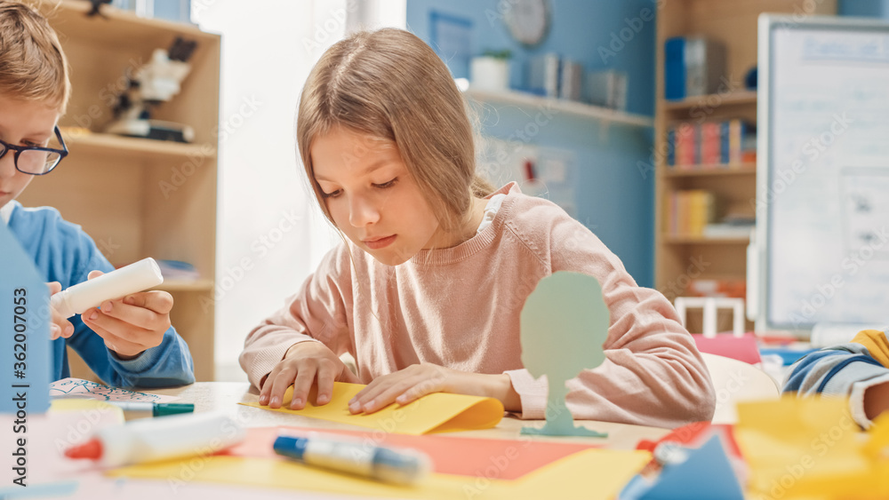 小学工艺美术课：可爱的金发小女孩和同学在汉族玩得很开心