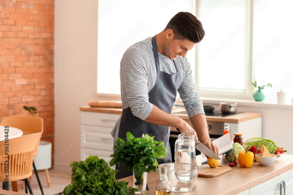 年轻人拿着食谱在厨房准备新鲜柠檬水