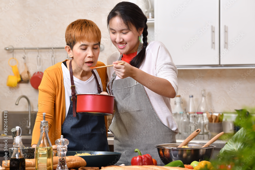 充满爱的亚洲母女家庭在厨房烹饪，一起做健康的食物，感觉很好