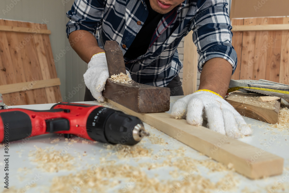 木匠在车间里用木工制作建筑材料或木制家具。Th