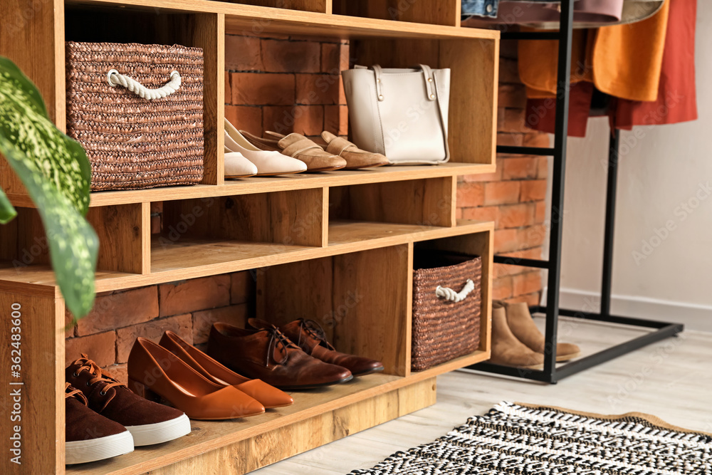 Shelf unit with shoes and accessories in stylish modern hallway