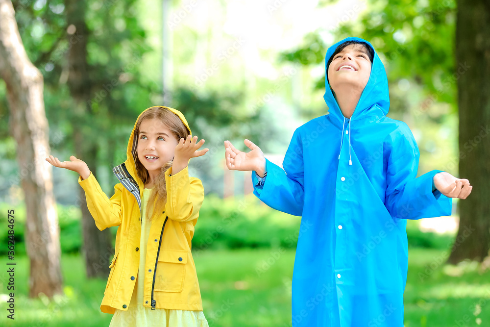 可爱的小孩在公园里穿着雨衣