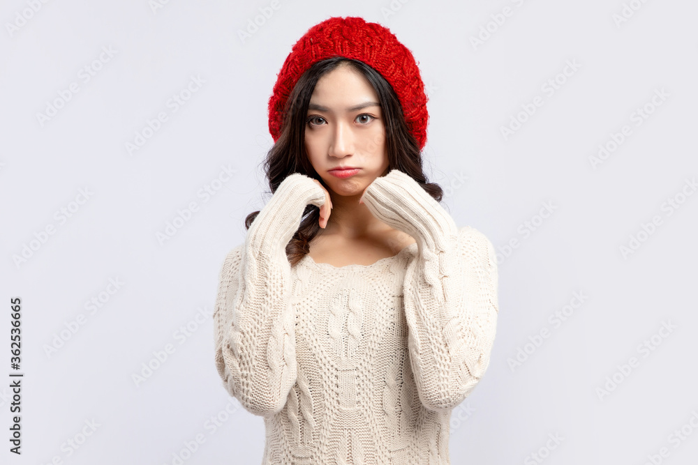 A beautiful asian girl in a beige sweater and a red velvet hat

