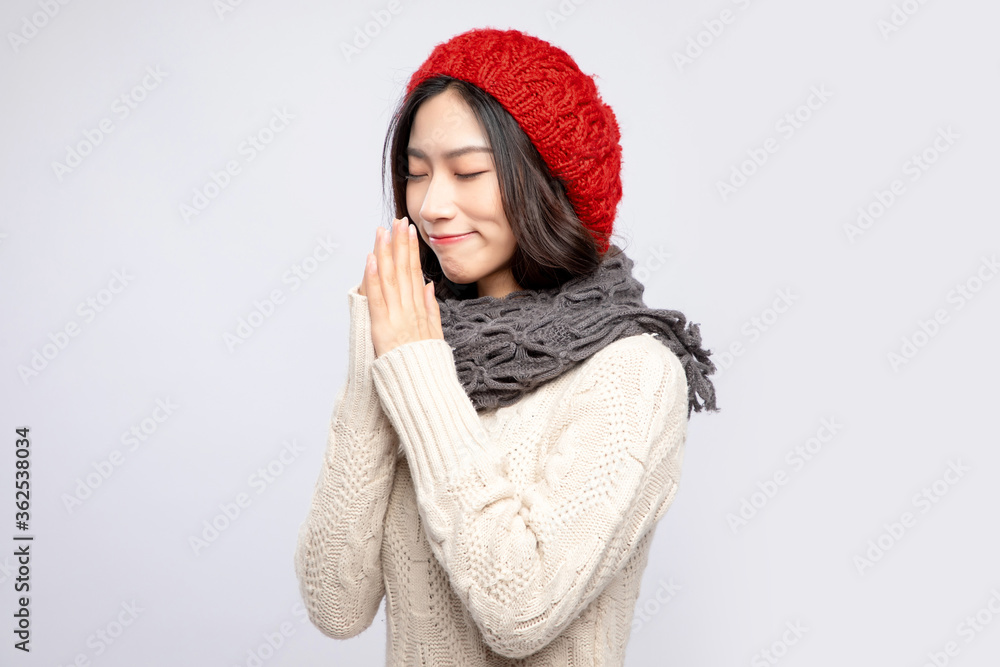 A beautiful asian girl in a beige sweater and a red velvet hat

