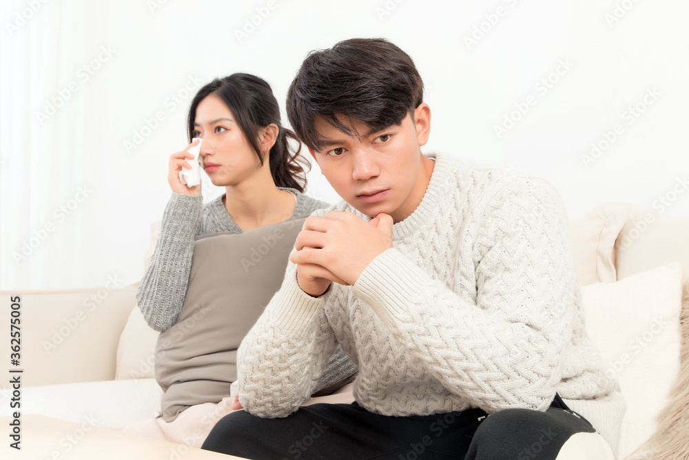 In winter, a pair of young Asian lovers sit on the sofa. Dont get angry