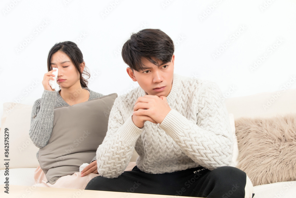 In winter, a pair of young Asian lovers sit on the sofa. Dont get angry