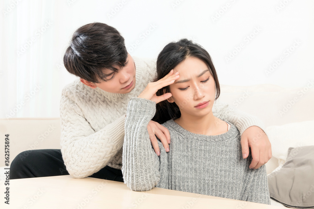 In winter, a pair of young Asian lovers sit on the sofa. Dont get angry