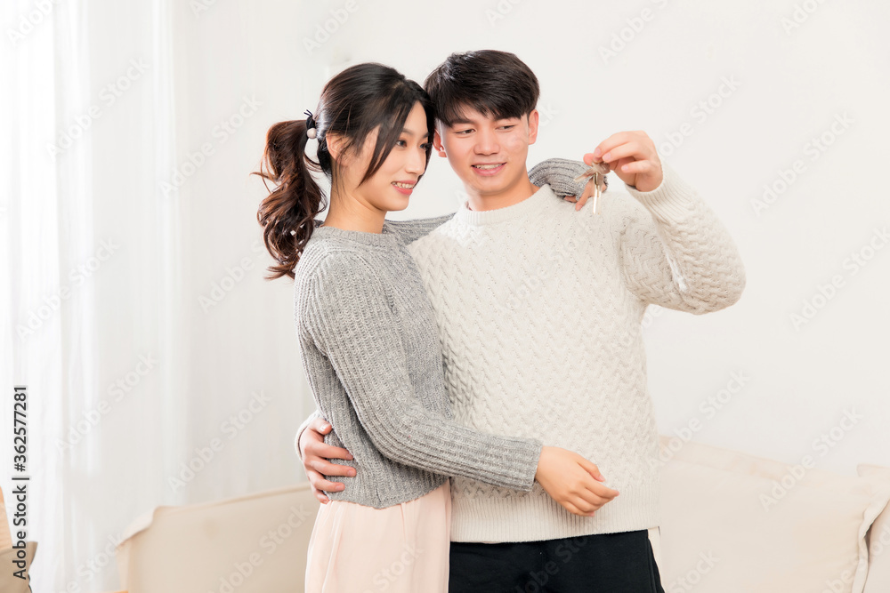 A pair of intimate young Asian lovers enter their new house with their keys