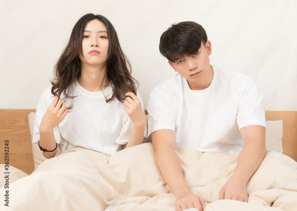 A young asian couple who are quarrelling in bed

