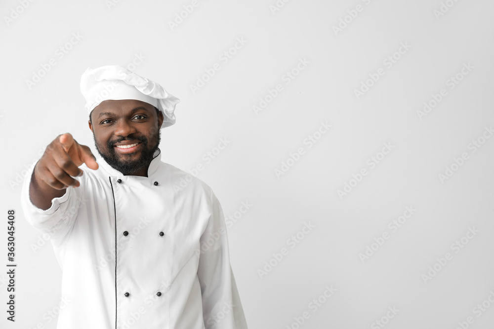 Male African-American chef pointing at viewer on white background