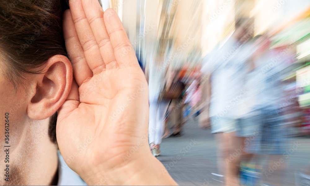 Human holds his hand near his ear and listening