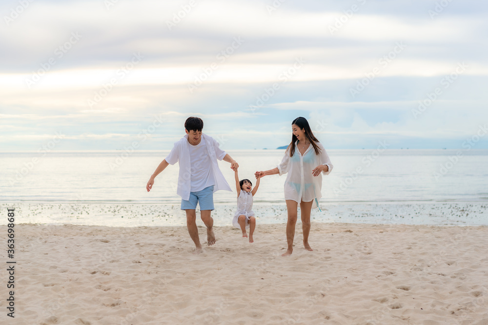 Happy Asian family holidays during joyful father, mother and daughter running together along summer 