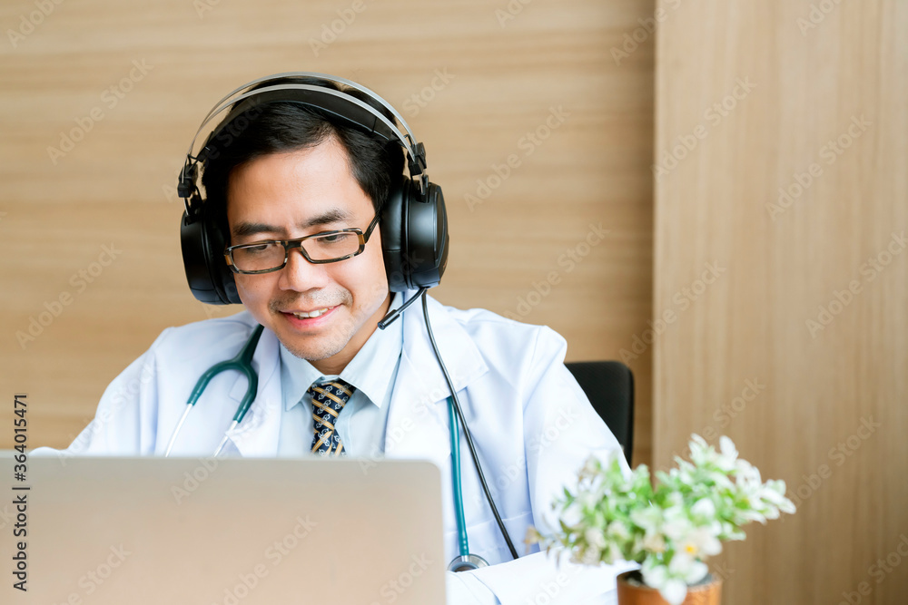 Young attractive Asian male doctor diagnosis talking and looking to camera in video conference ,Posi