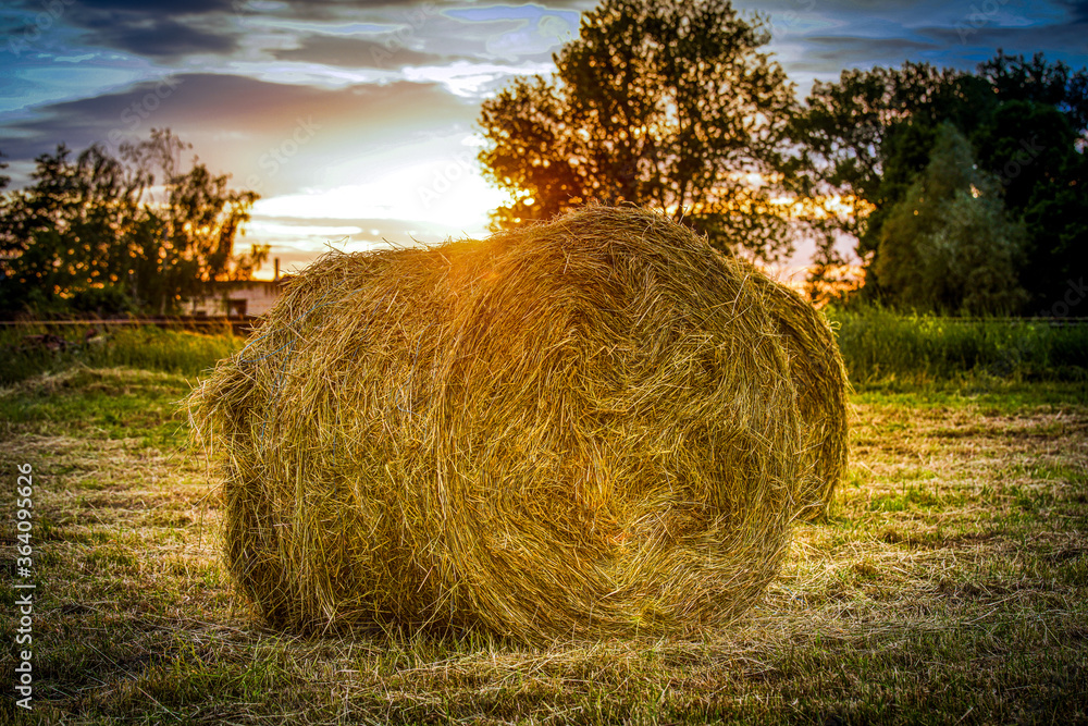 Strohballen auf einem Feld mit Sonnenuntergang