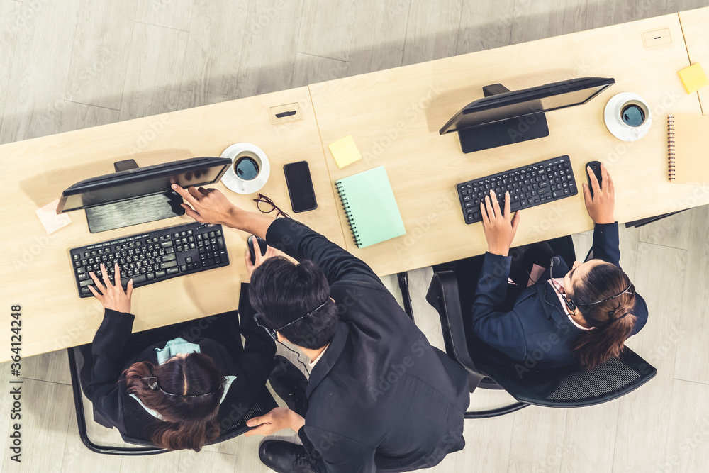 Business people wearing headset from top view in office working with computer to support remote cust