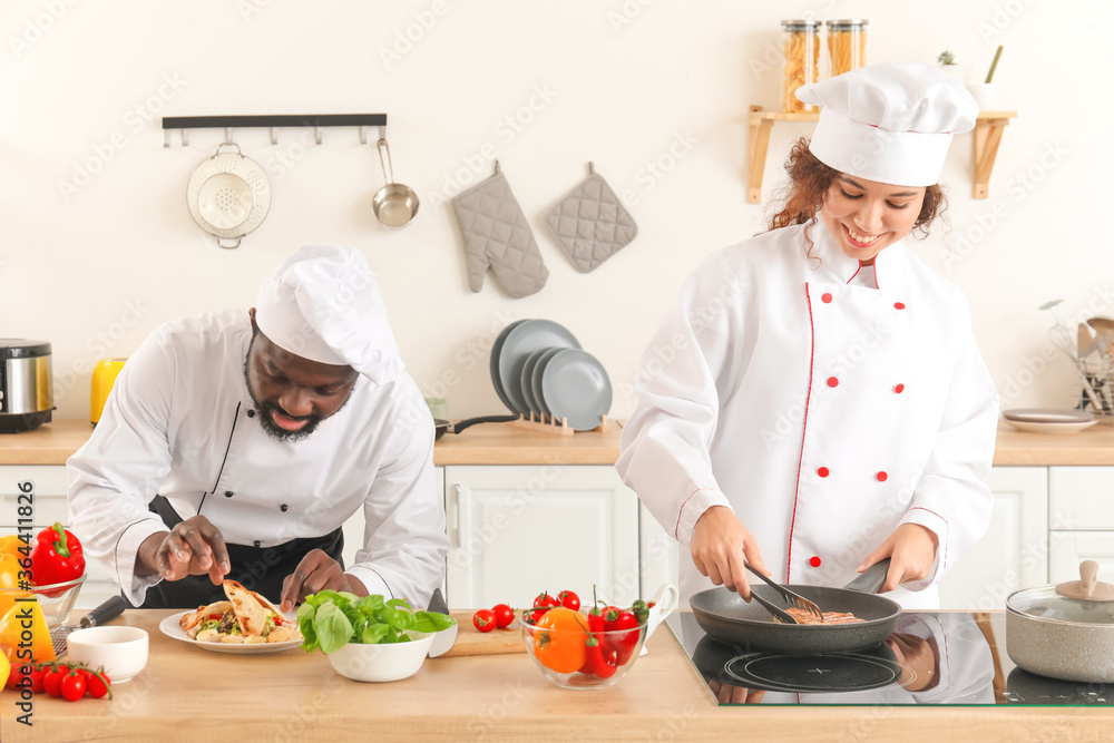 African-American chefs cooking in kitchen