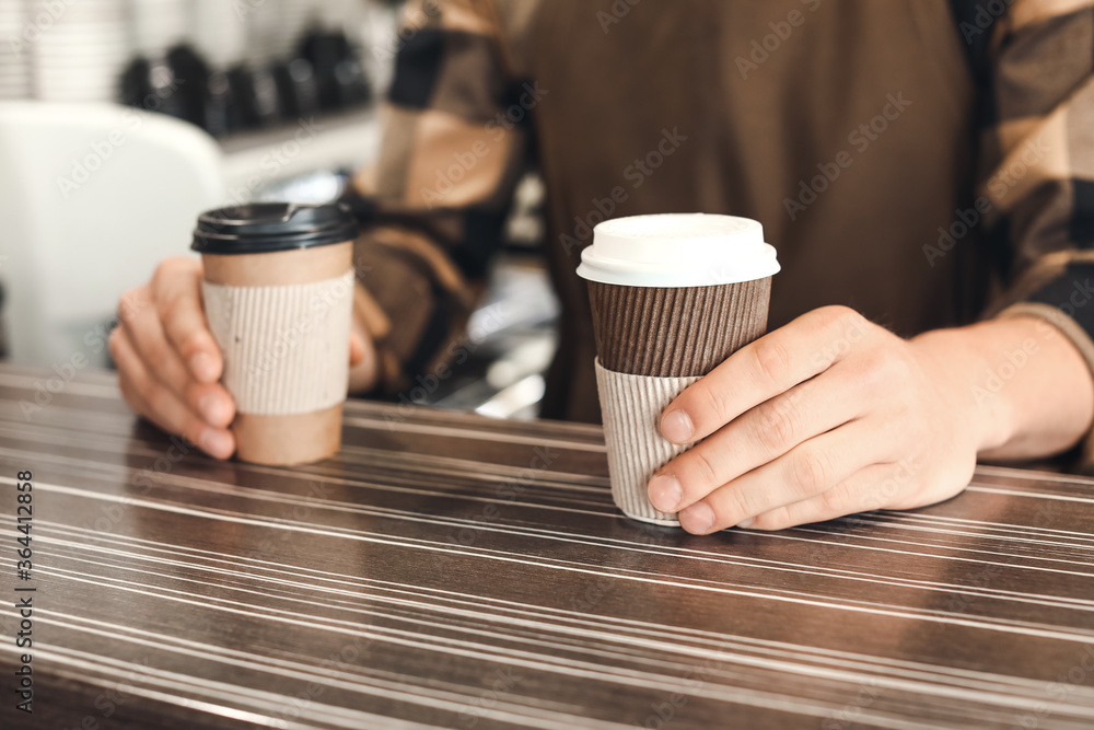 年轻男性咖啡师在咖啡馆喝咖啡，特写