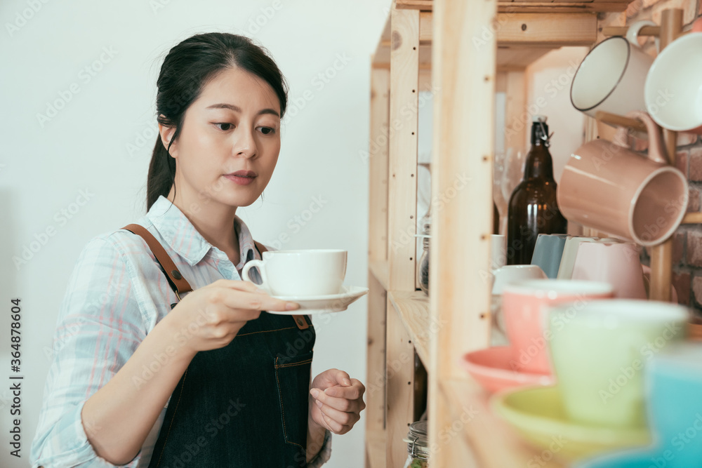 可爱的亚裔日本女服务员拿着盘子里的干净白杯子做浓咖啡。年轻女人b