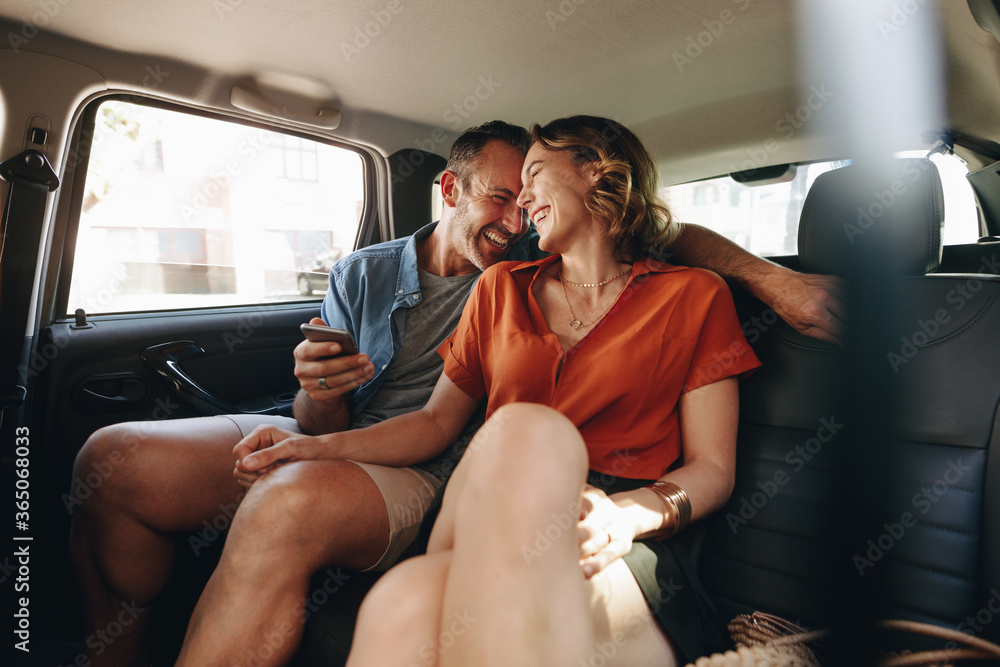 Cheerful couple in rear seat of car