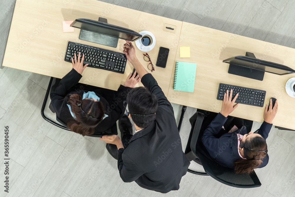 Business people wearing headset from top view in office working with computer to support remote cust