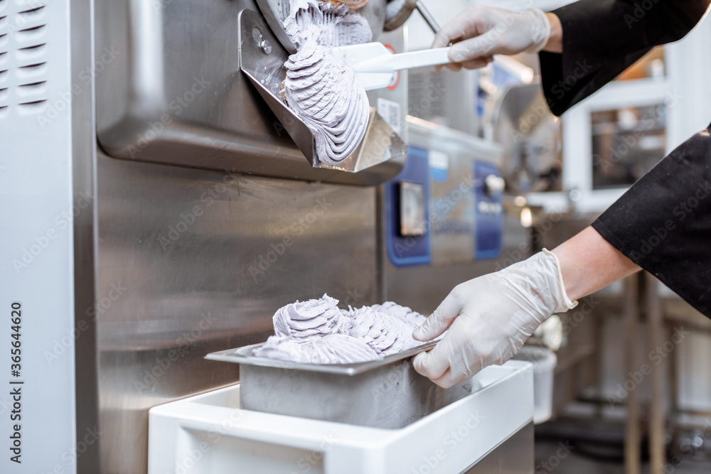 Pile of ready-made ice cream falling out of the freezer at the manufacturing, close-up