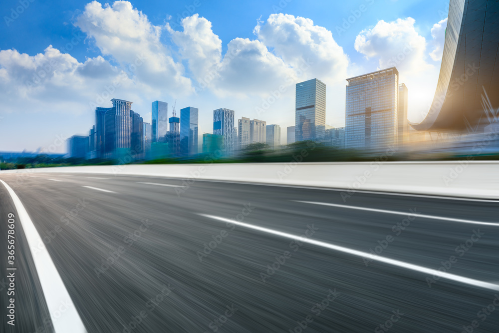 Motion blurred asphalt road and city commercial building in shenzhen,China.