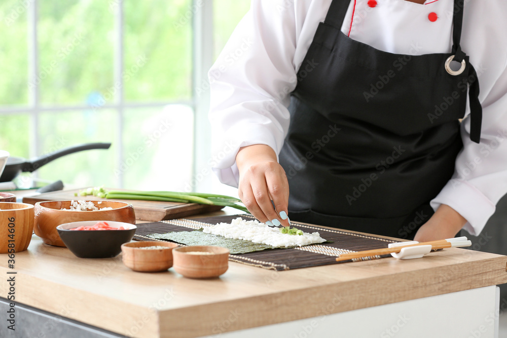 Beautiful Asian chef cooking in kitchen, closeup