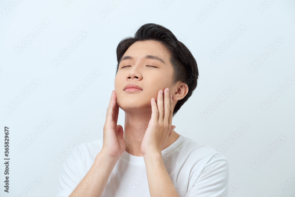 Handsome man touching his face close up portrait studio on white background