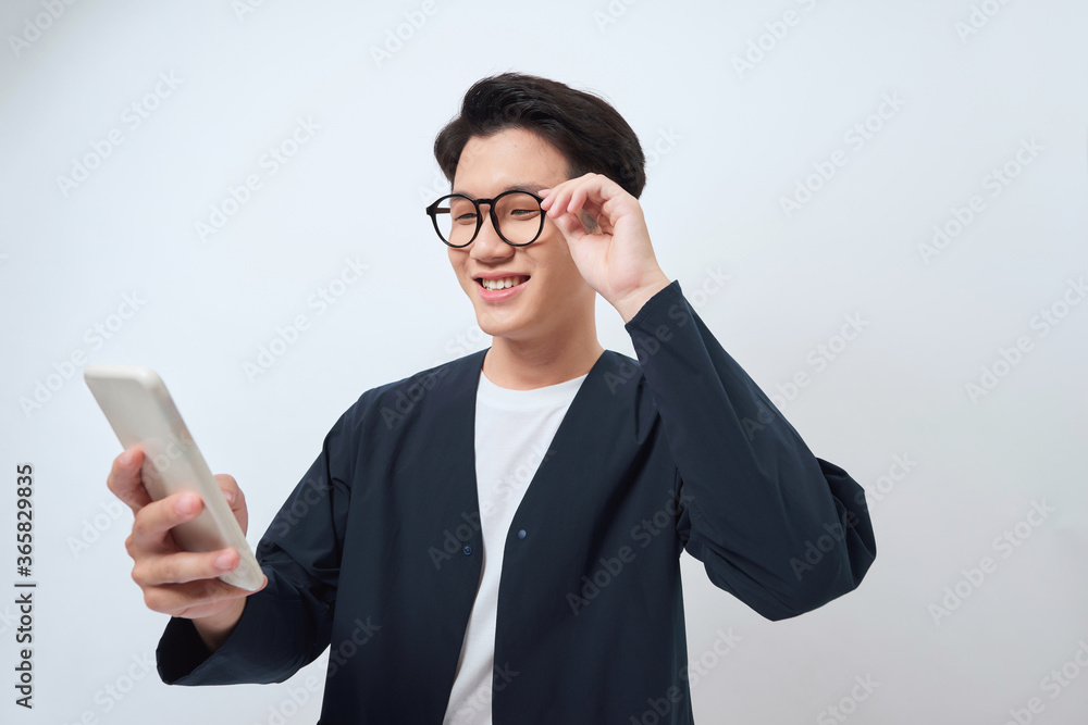 Young handsome Asian man being surprised after reading message from smarrtphone studio short isolate