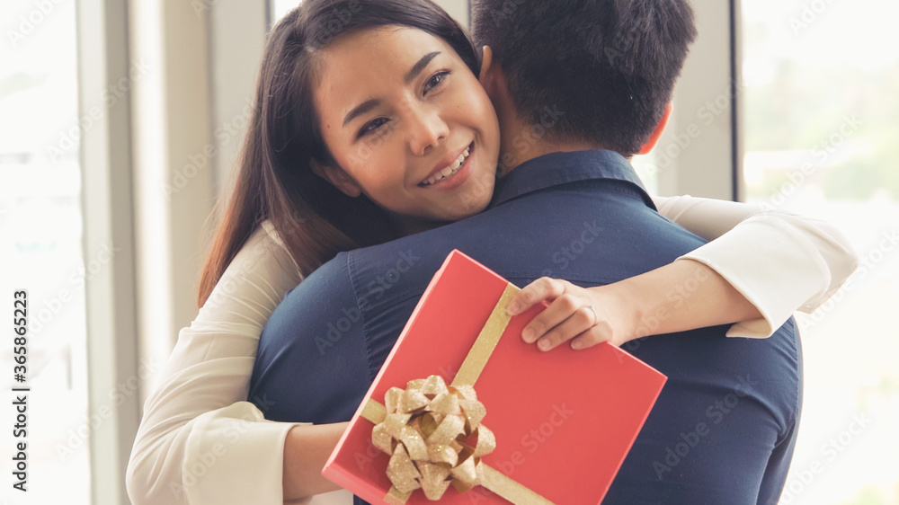 Romantic couple giving gift to lover at restaurant . Happy couple lifestyle .