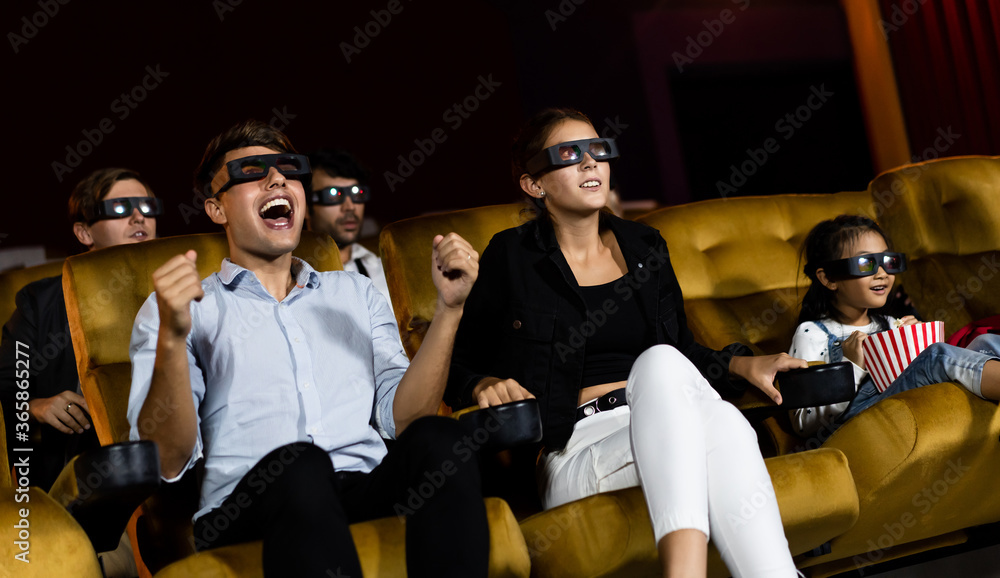 Group of people watch movie with 3D glasses in cinema theater with interest looking at the screen, e