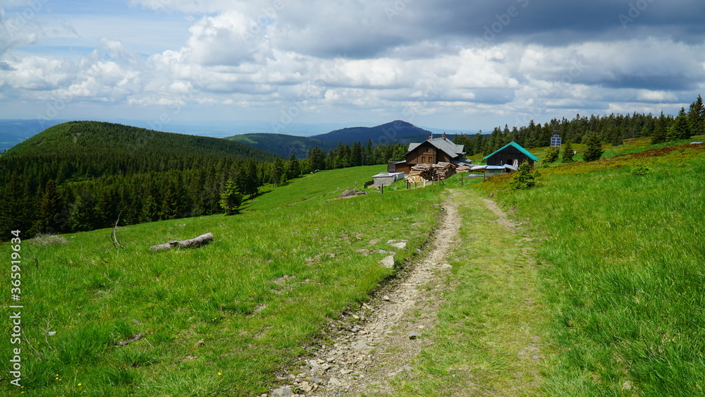 schronisko na tle gór i zachmurzonego nieba i szlakiem