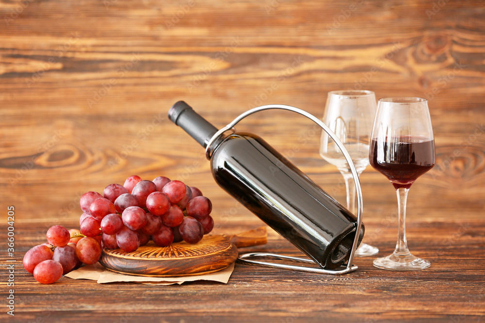 Holder with bottle of wine and glasses on table