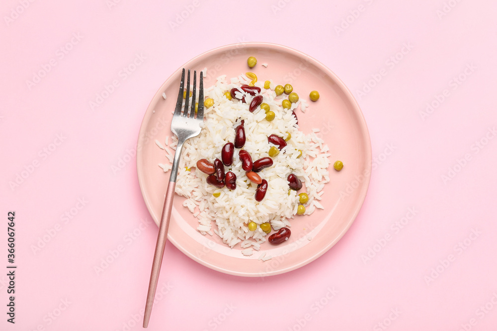 Plate with tasty rice and beans on color background