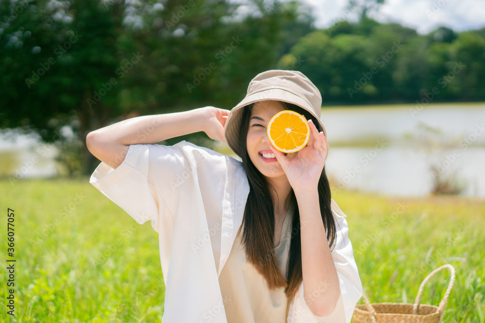 Asian woman she is showing orange She came to picnic with her friends.