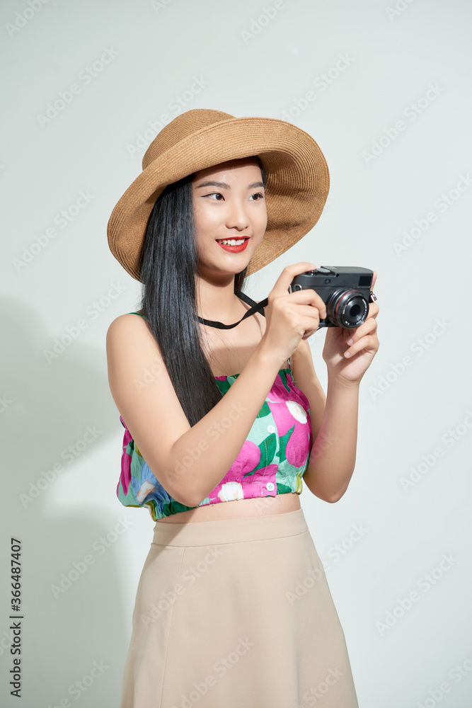 Beautiful happy cute asian woman in casual summer clothes takes photos holding retro photographic ca