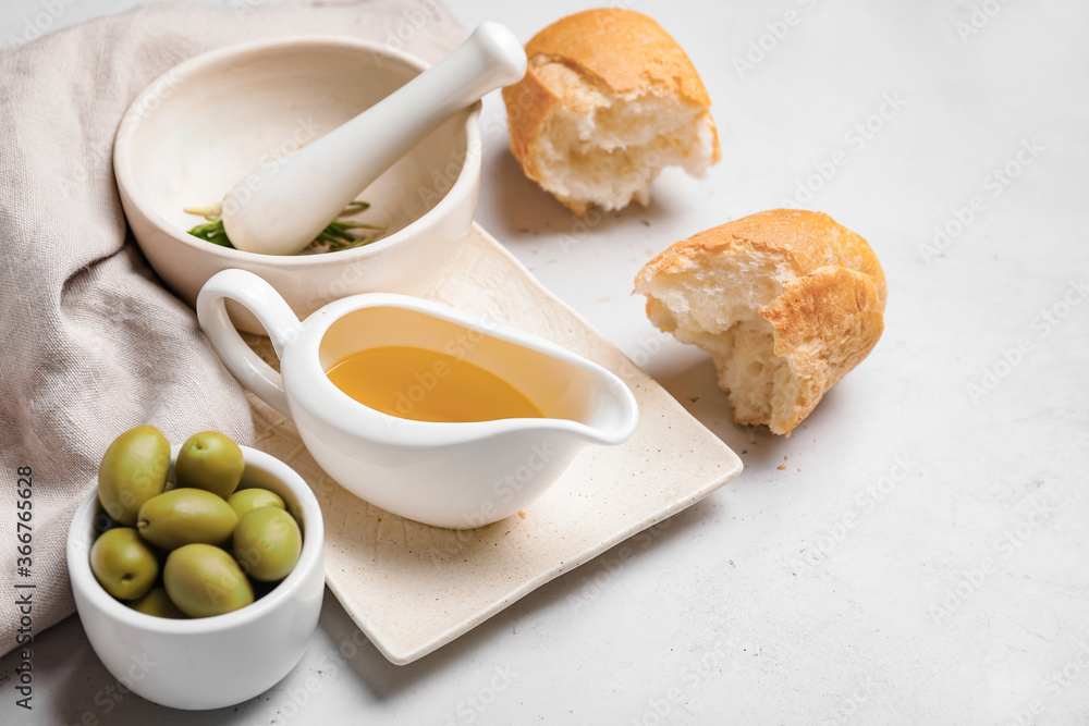 Gravy boat of tasty olive oil and bread on white background