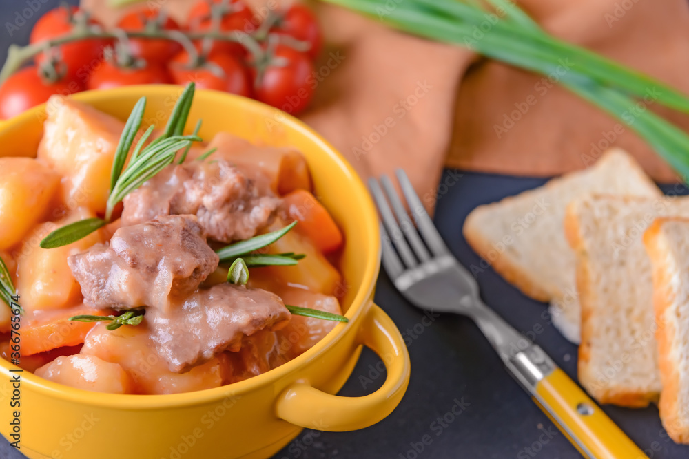 Pot with tasty beef stew on table