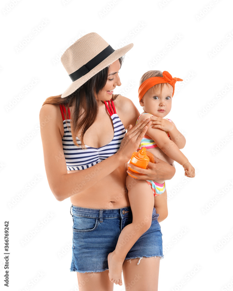 Mother and her little daughter with sunscreen cream on white background