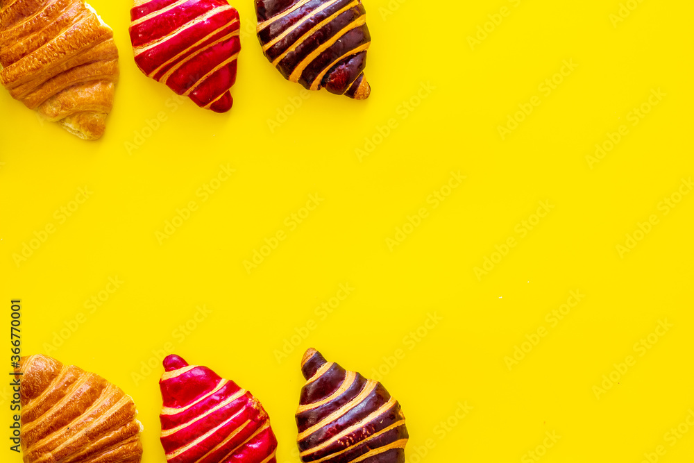 Frame of croissants - fresh bakery on yellow background. Top view