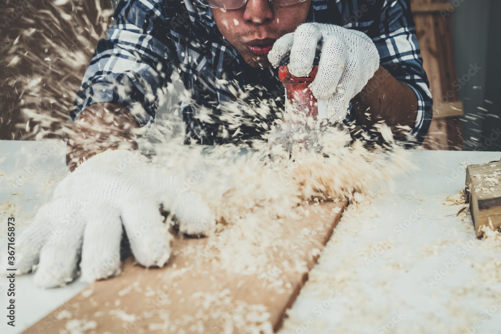 Carpenter working on wood craft at workshop to produce construction material or wooden furniture. Th