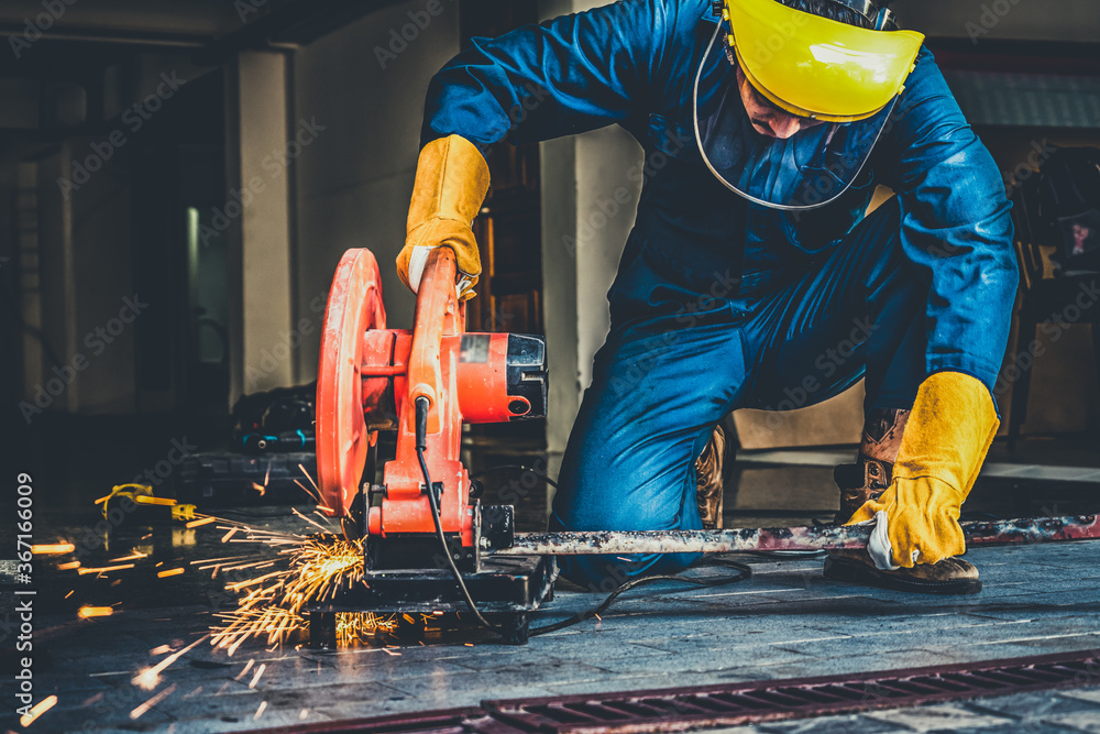 Professional mechanic is cutting steel metal with rotating diamond blade cutter. Steel industry and 