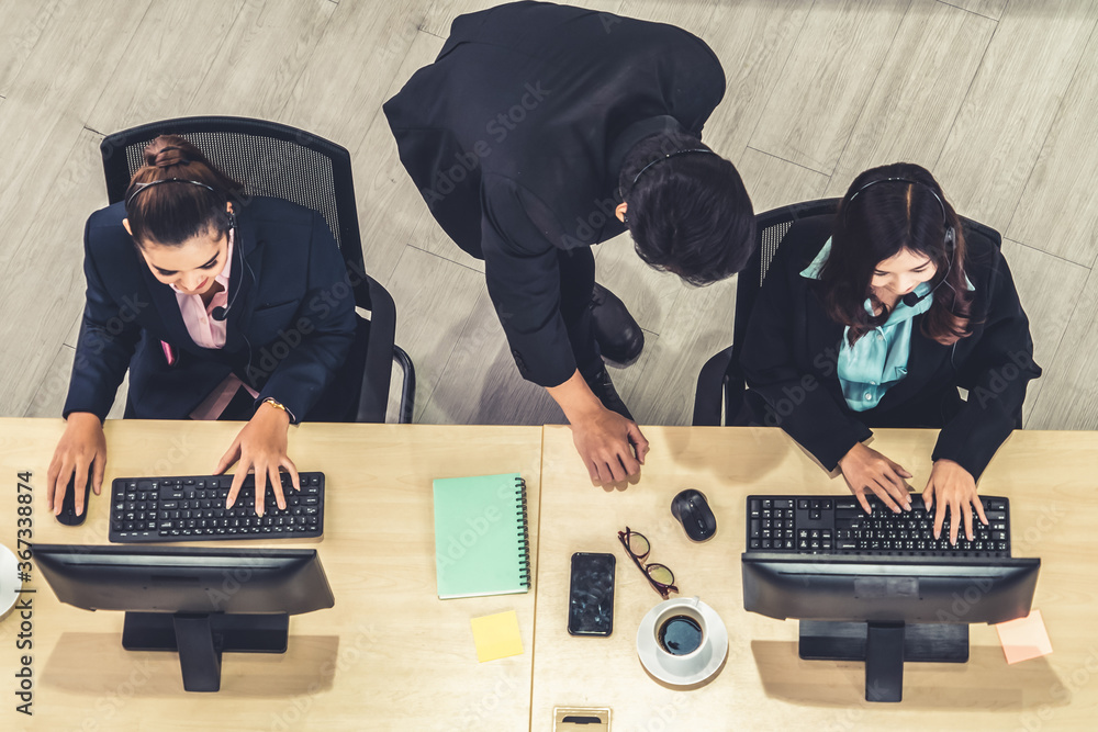 Business people wearing headset from top view in office working with computer to support remote cust