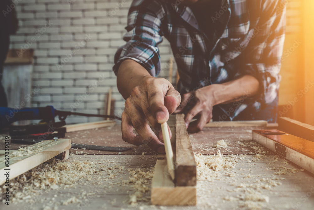 Carpenter working on wood craft at workshop to produce construction material or wooden furniture. Th