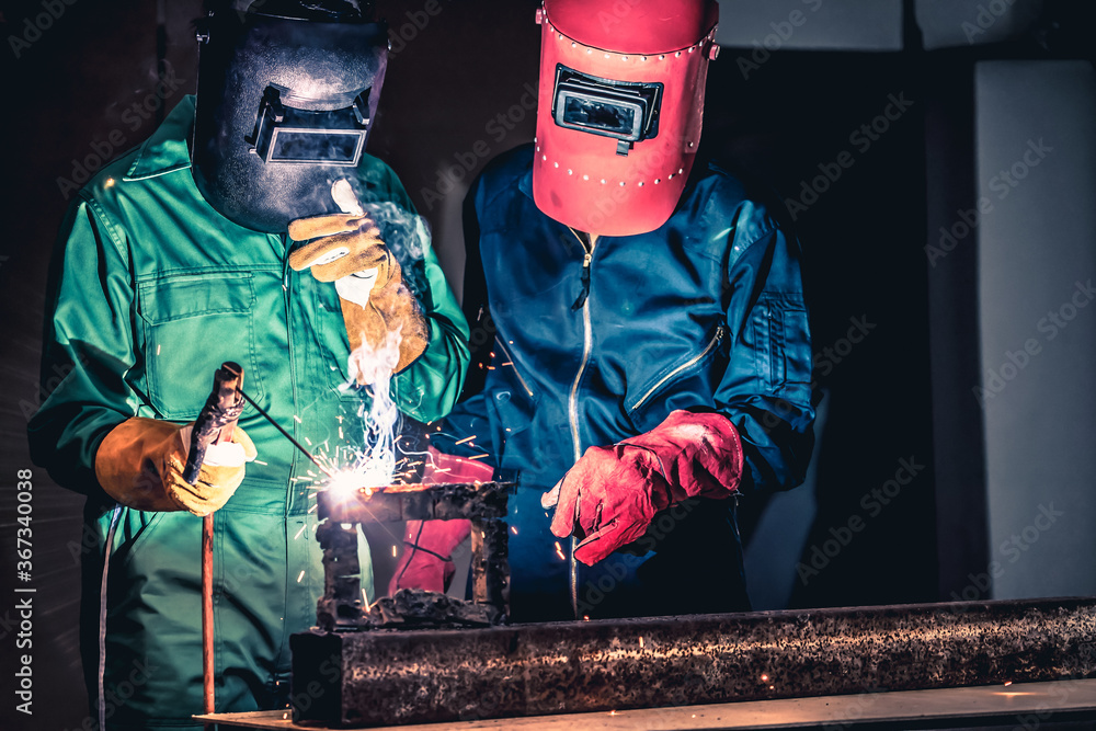 Metal welding steel works using electric arc welding machine to weld steel at factory. Metalwork man